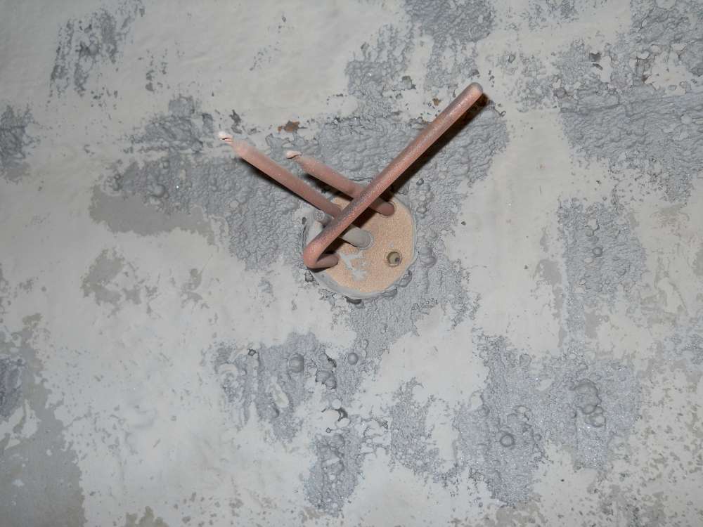 Prepared: pitted areas exposed around a fitting, ready for repair.