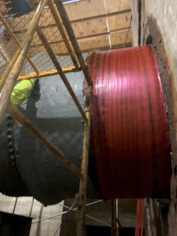 Belzona SuperWrap applied over the coated shell — the red laminate is the reinforcing wrap system.