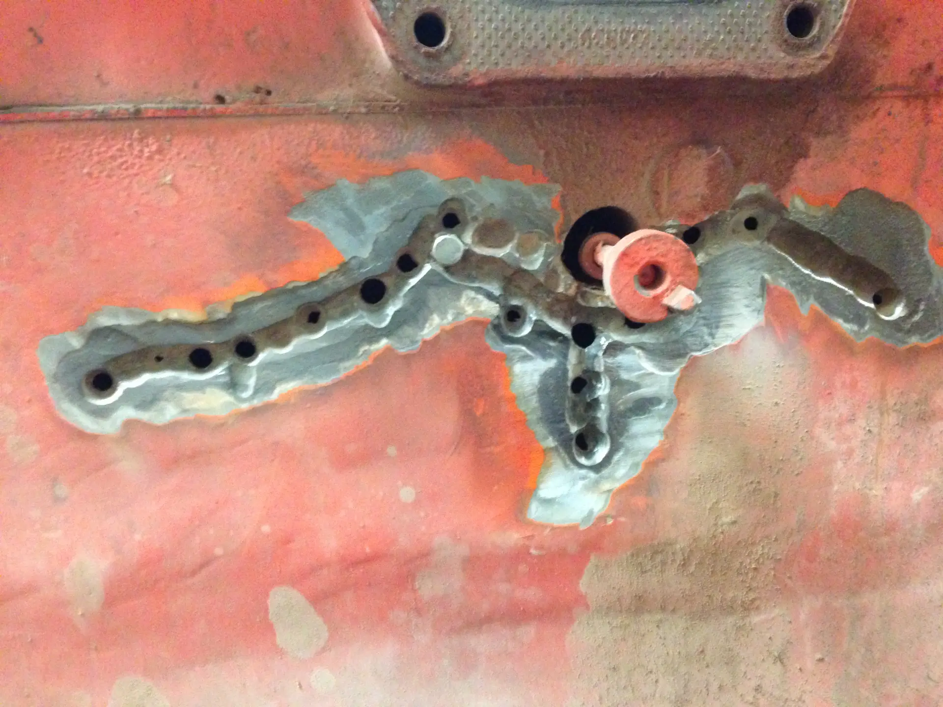 Locking pins set into the stitch holes to pull the fracture mechanically closed, with the surrounding area ground back to clean, profiled metal.