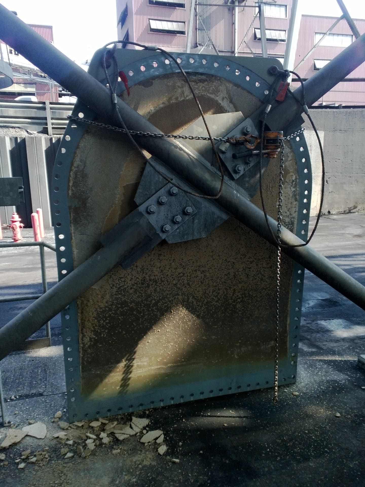 The cut-out door plate after removal, showing damage and buildup.
