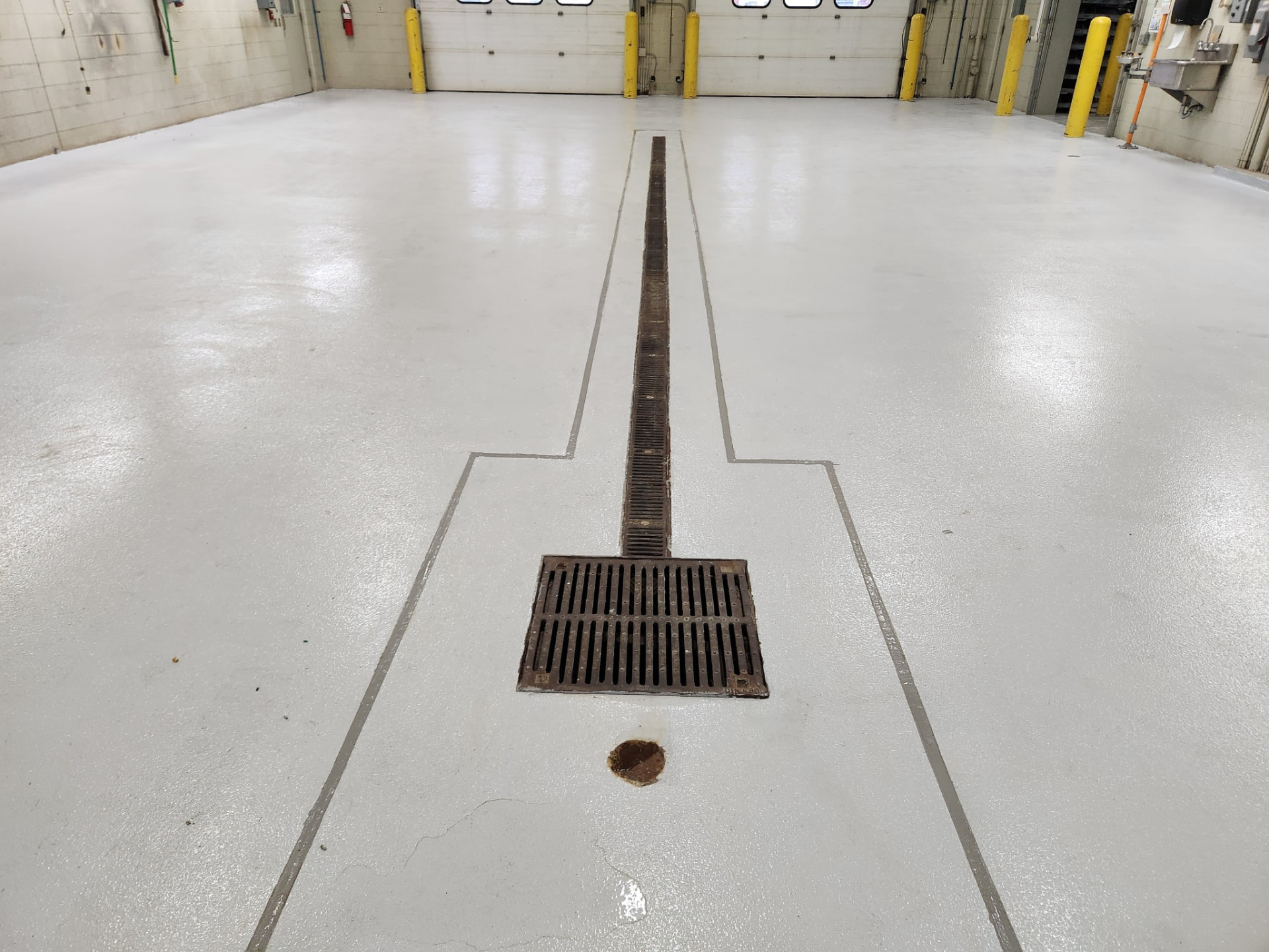After — weld shop: finished floor with rebuilt joints and clean transitions around the grates.