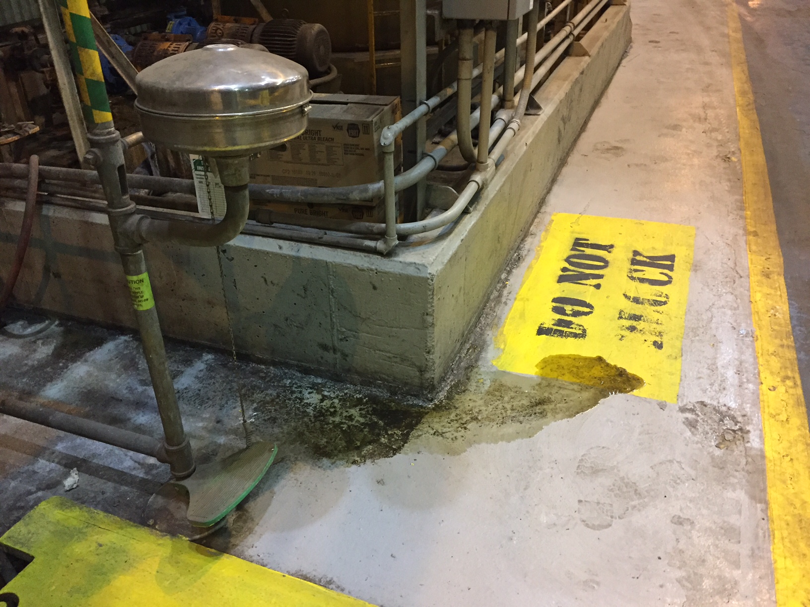 Fluid leaking onto the floor along the base of a concrete containment area