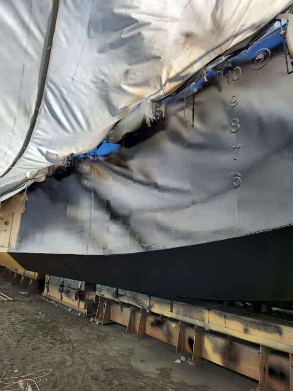 Topcoat along the hull side with draft marks masked and preserved.