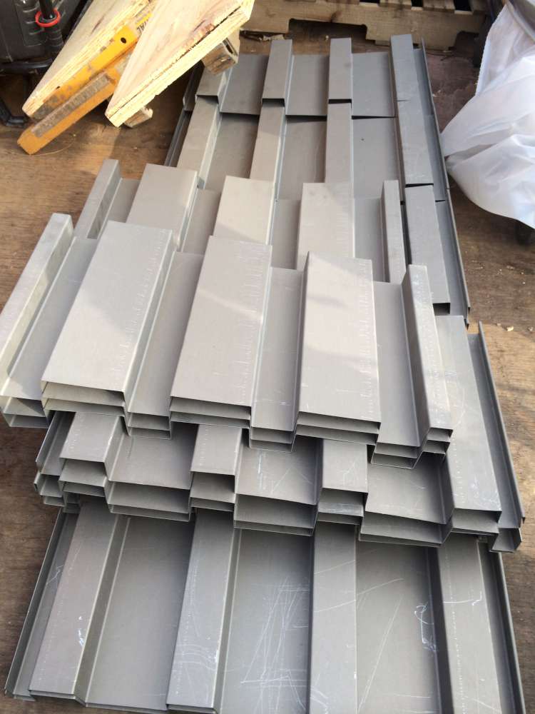 Damaged siding panels removed from the wall and stacked on site.