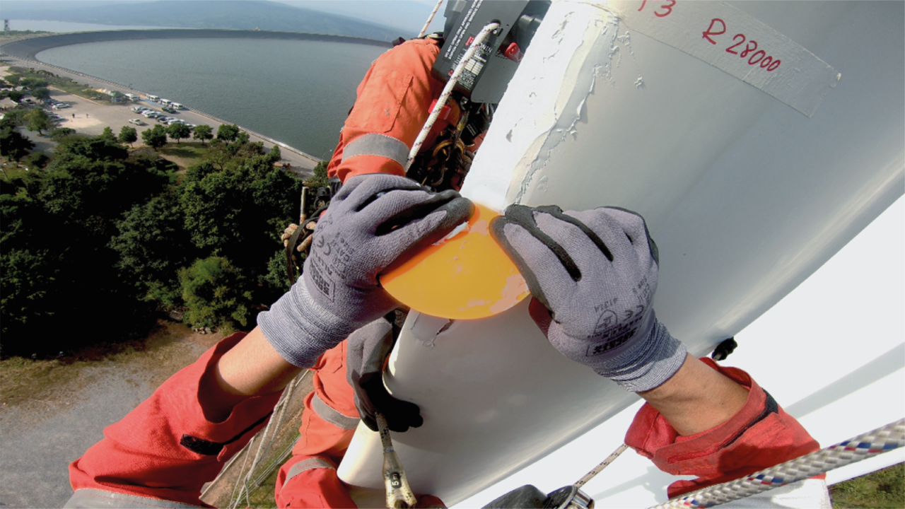 Technician applying Belzona to a wind turbine blade leading edge