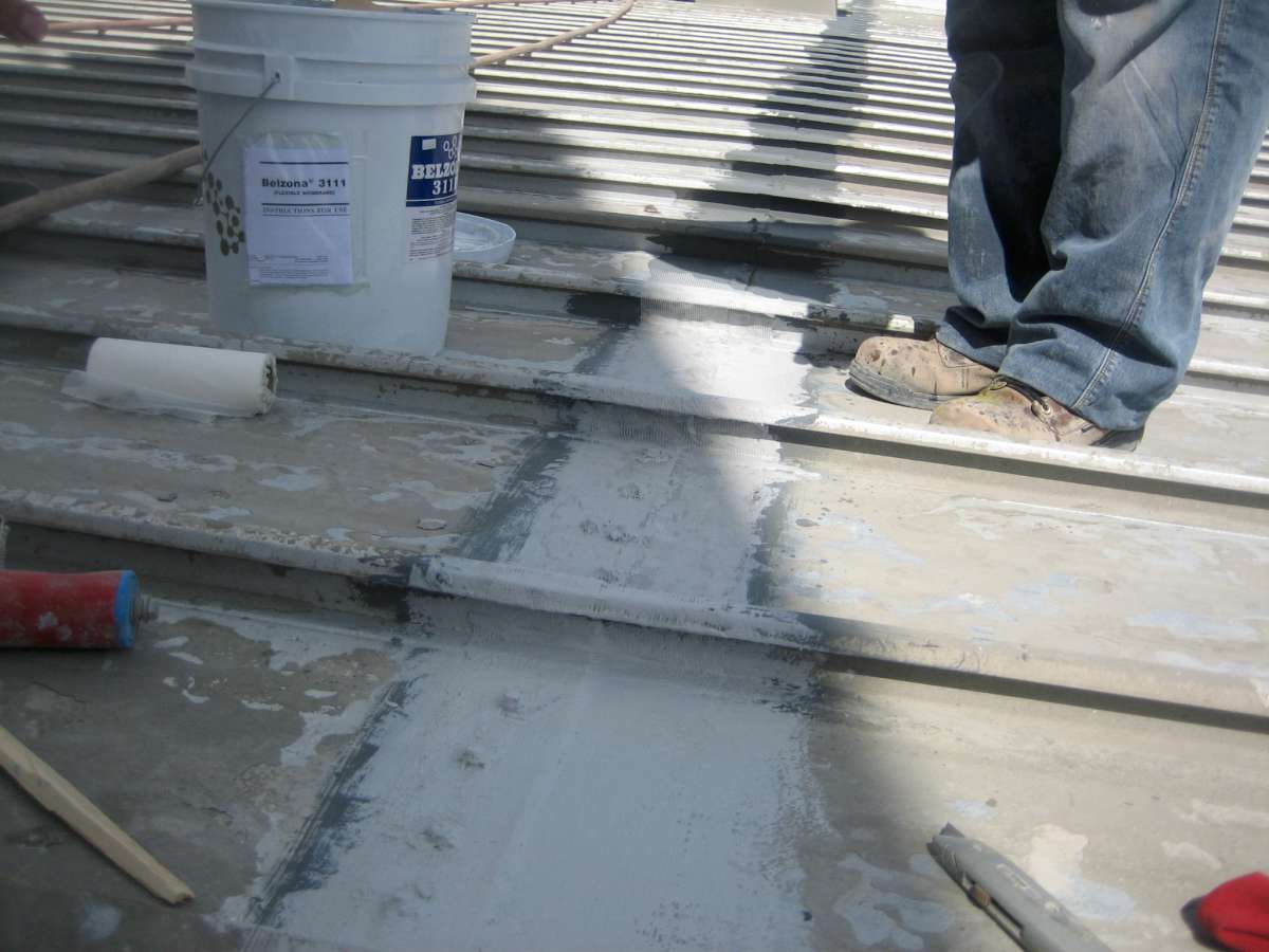 In progress: treated seams beside untreated ones, with the Belzona 3111 kit on the roof.