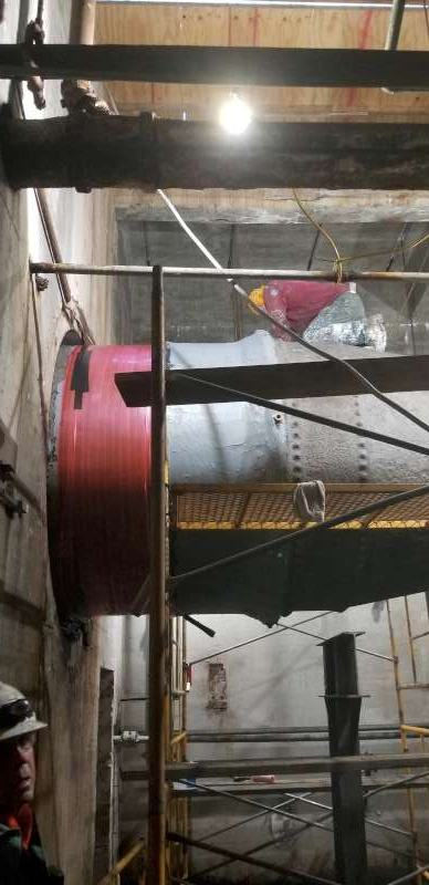 Work staged around the pipe circumference from scaffold so the main stayed in service.