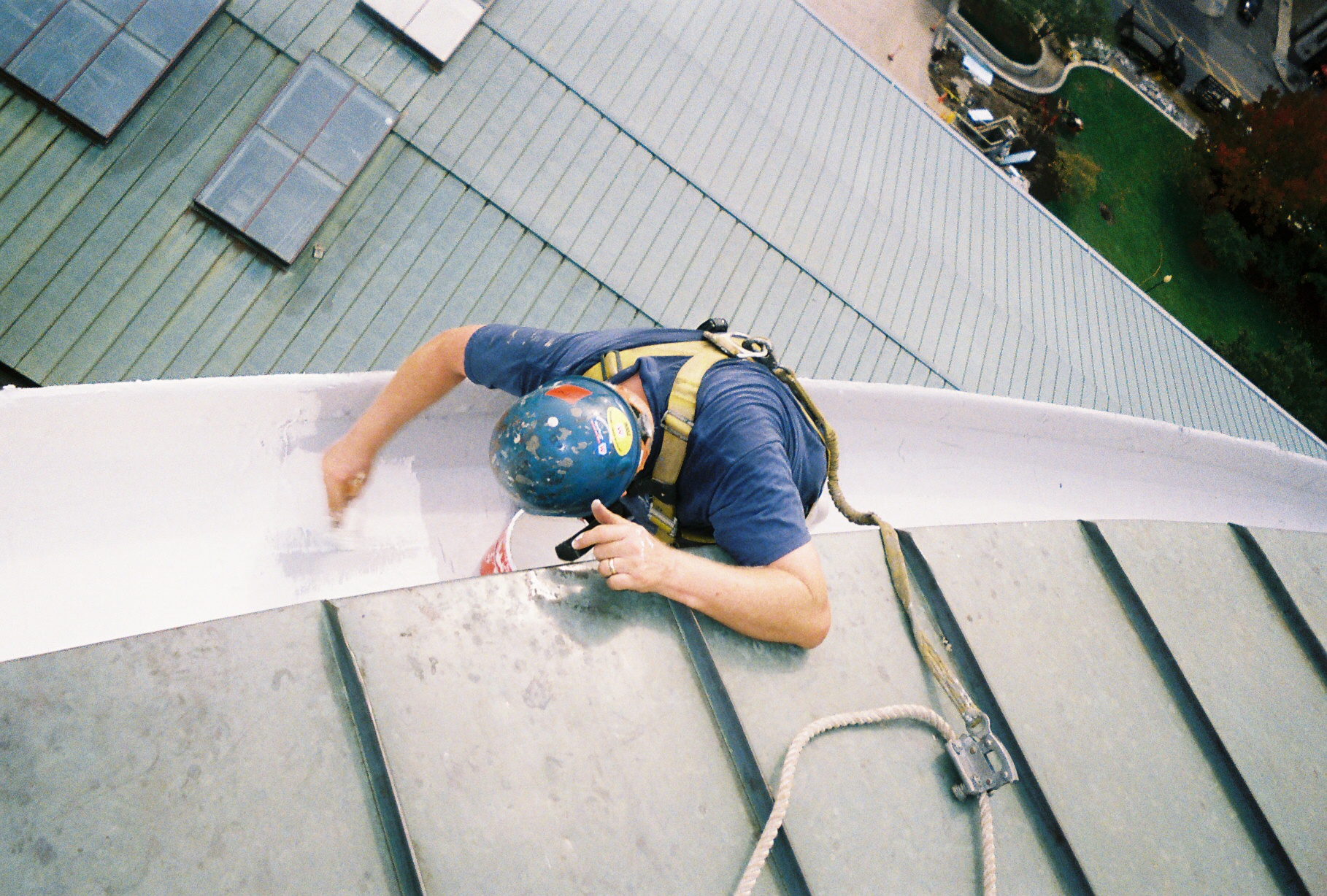 Technician hand-coating a high-rise roof edge