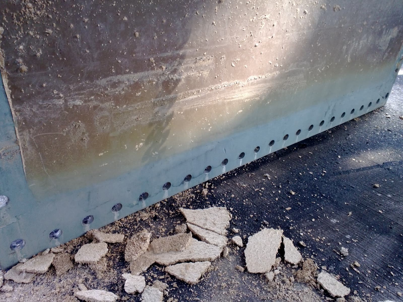 Close-up of the damaged door plate edge.